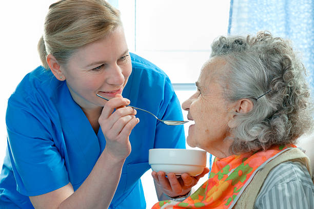 senior woman 90 years old being fed by a nurse